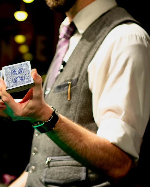 Magicien en gilet, un jeu de cartes à la main