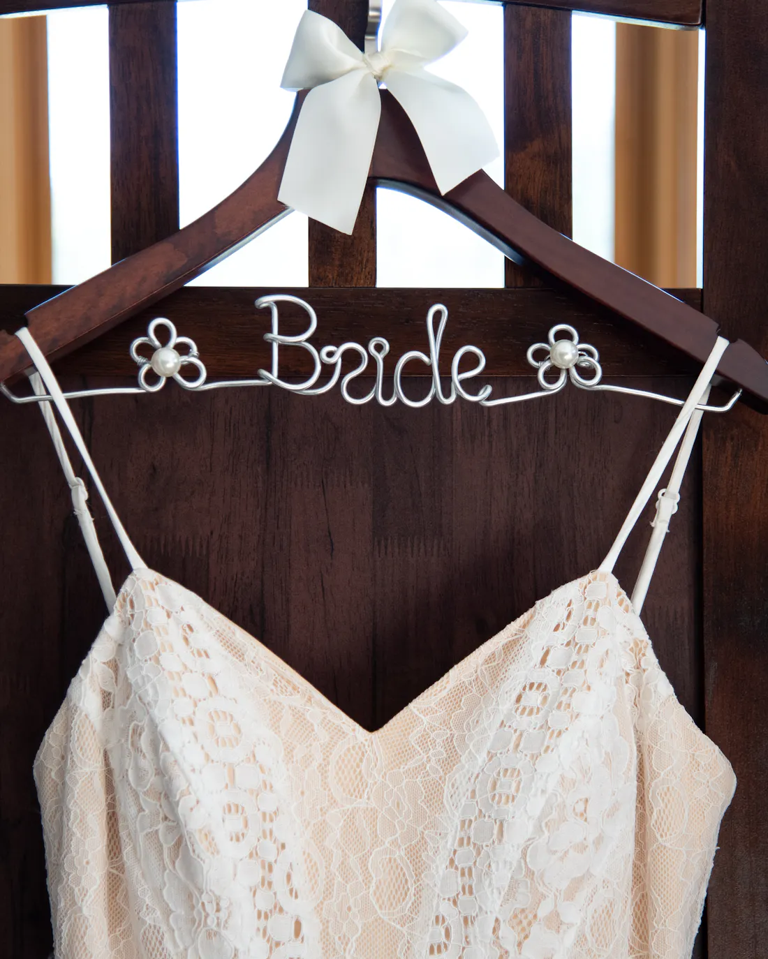Robe de mariée en dentelle sur un cintre de bois