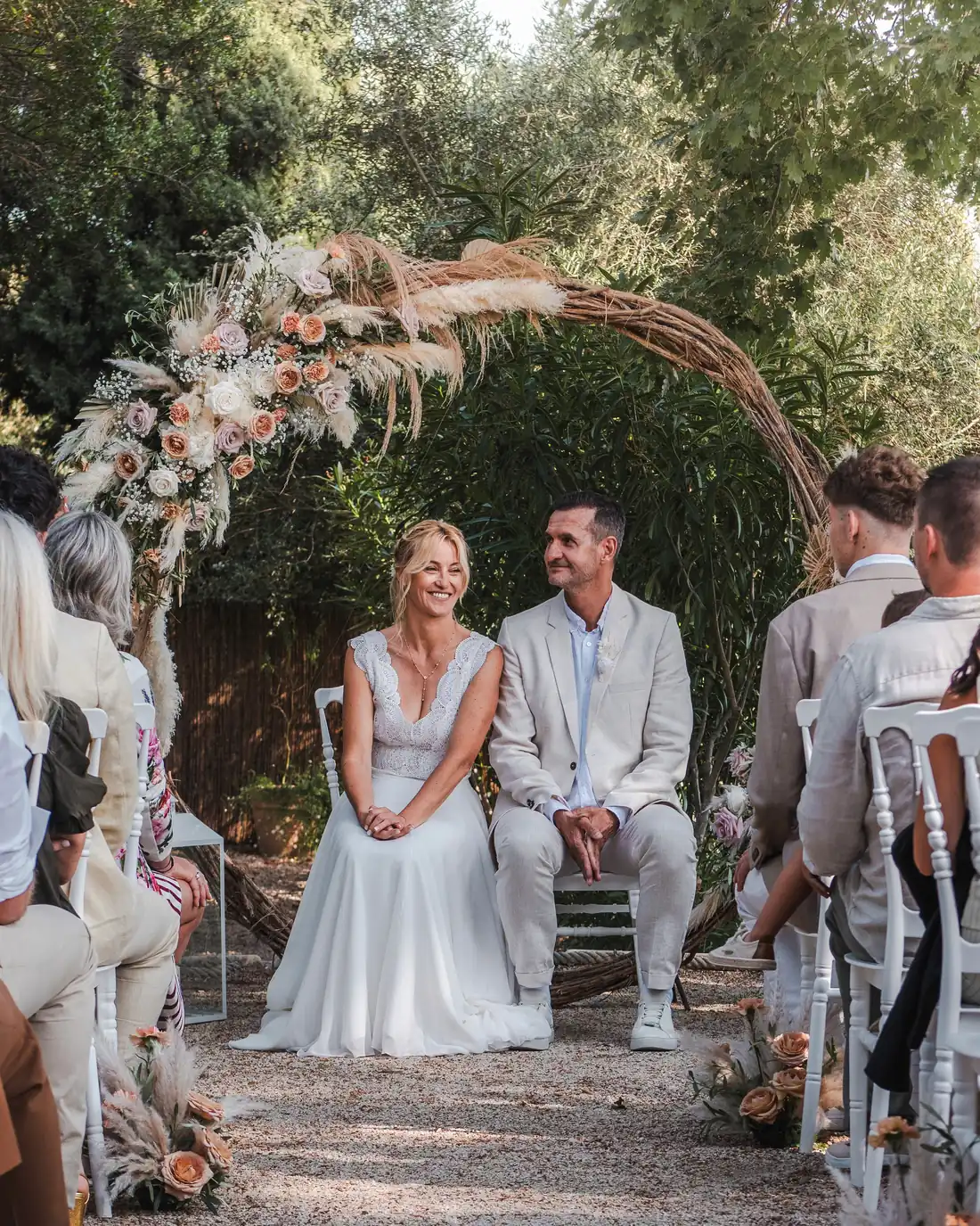 Cérémonie de mariage en extérieur sous une arche fleurie