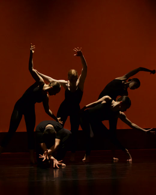 Silhouettes de danseurs sur une scène orangée